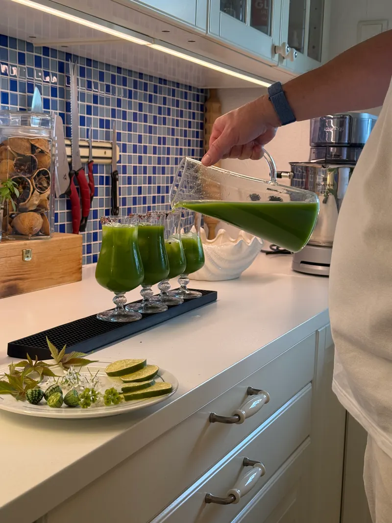 Grüner Cocktail wird in vier Gläser eingeschenkt