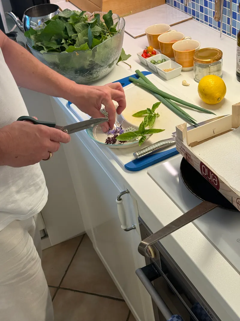 Arbeitsfläche mit Kräutern, Zitrone, Kirschtomaten und Schneidebrett